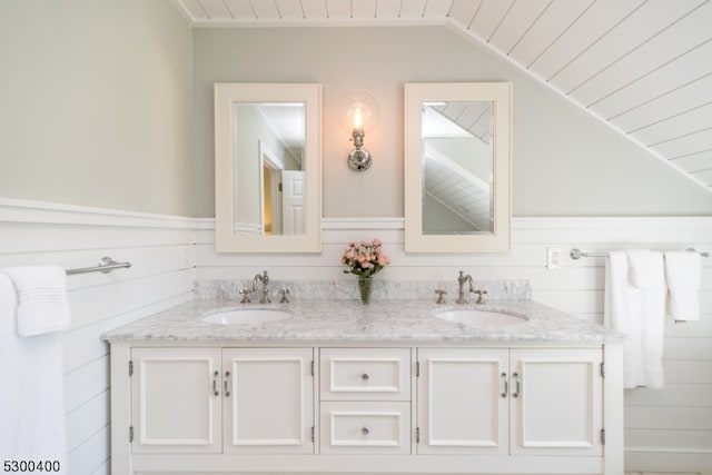 bathroom with lofted ceiling and double sink vanity