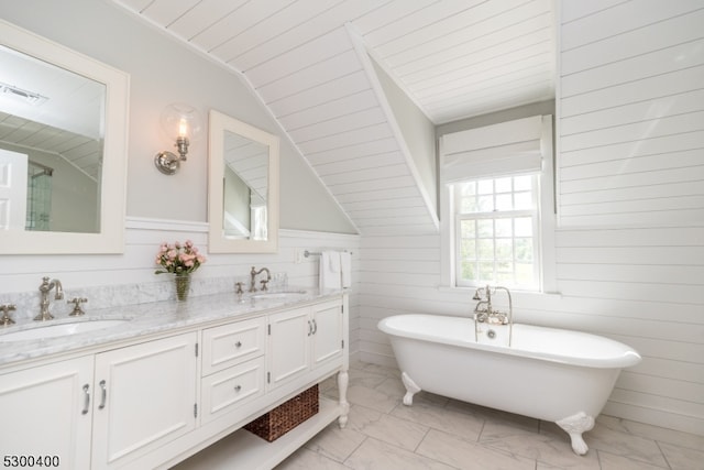 bathroom with dual vanity, tile patterned floors, a tub to relax in, and vaulted ceiling