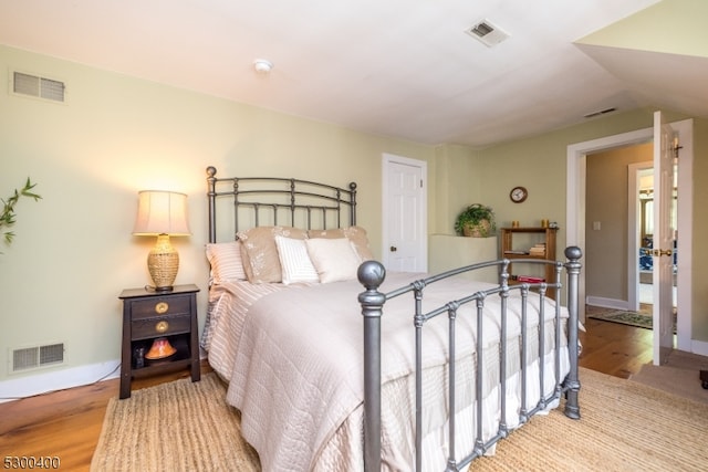 bedroom featuring wood-type flooring and vaulted ceiling