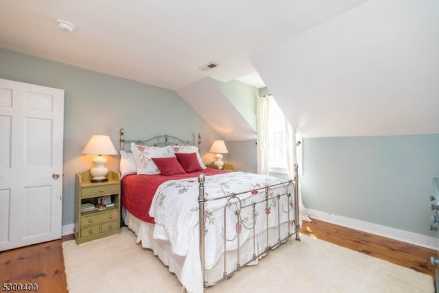 bedroom featuring vaulted ceiling and light hardwood / wood-style flooring