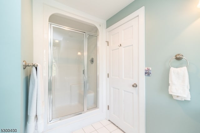 bathroom featuring a shower with shower door and tile patterned floors