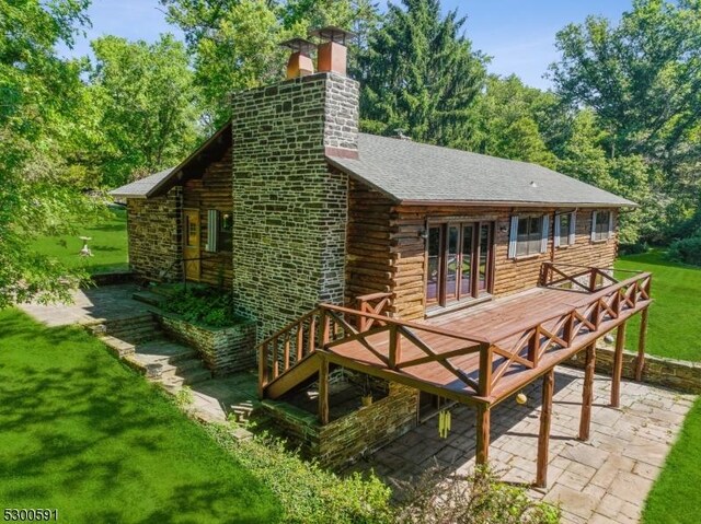 cabin featuring a patio area and a front lawn