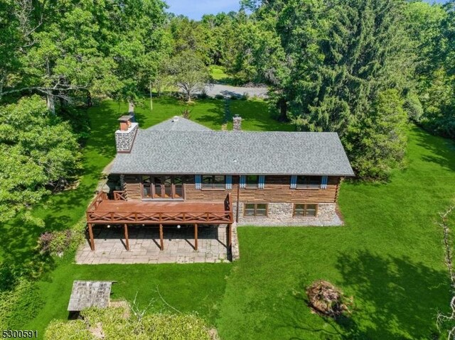 rear view of property featuring a deck and a yard