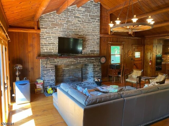 living room with a fireplace, wooden walls, high vaulted ceiling, hardwood / wood-style floors, and wood ceiling