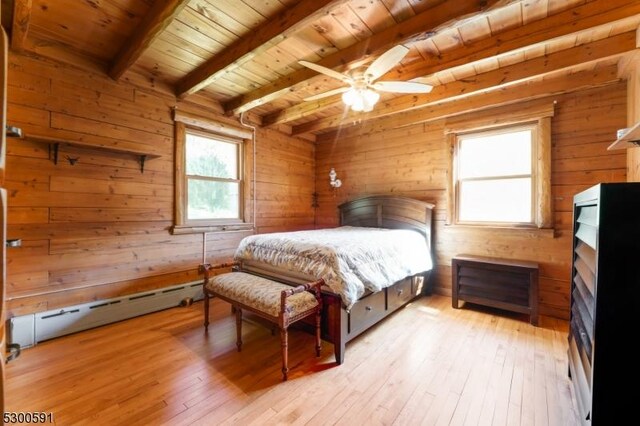 bedroom featuring wood ceiling, wood walls, a baseboard heating unit, and light hardwood / wood-style floors