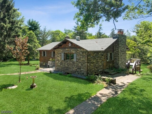 rear view of property with a yard, a wooden deck, and a patio