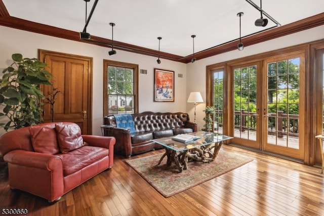 living room with wood-type flooring and ornamental molding