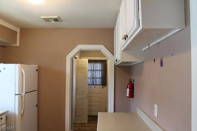 kitchen with white cabinetry and white fridge