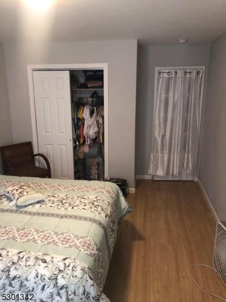 bedroom with a closet and hardwood / wood-style floors