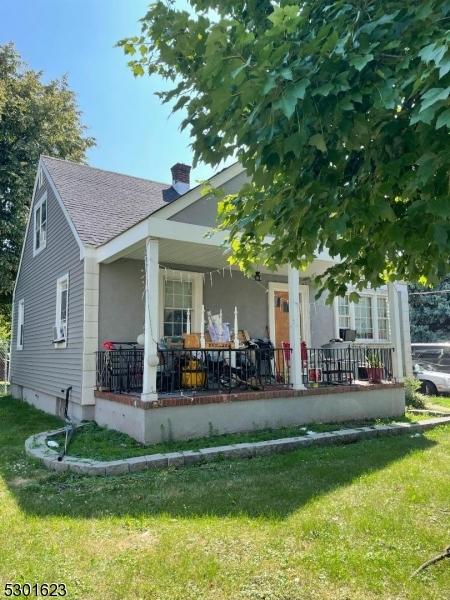 back of property with a porch and a yard