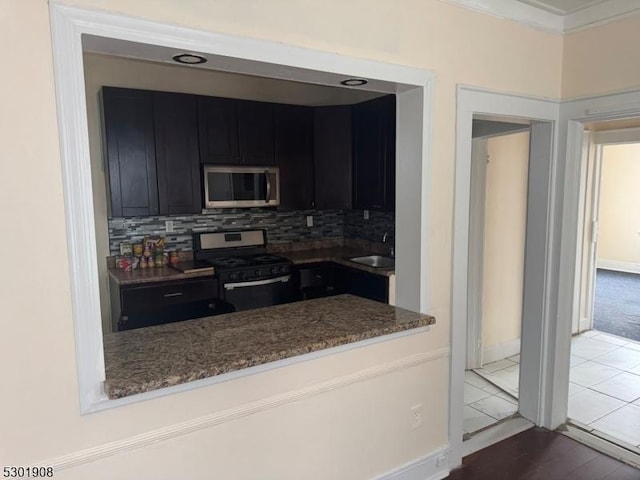 70 Campfield St, Irvington Twp, NJ 07111 - kitchen featuring a sink, tasteful backsplash, appliances with stainless steel finishes, dark cabinets, and dark stone counters