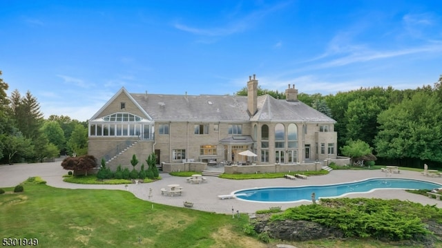 back of house featuring a patio area and a lawn