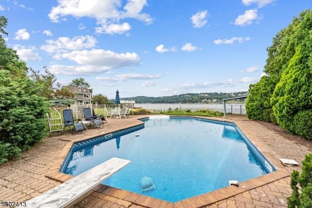 view of swimming pool featuring a diving board