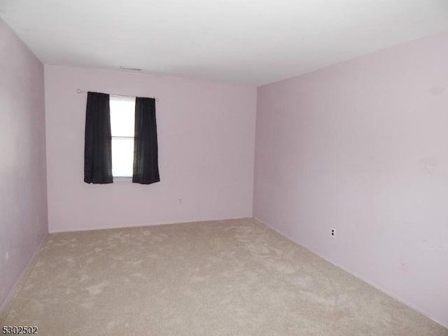 unfurnished room featuring light colored carpet