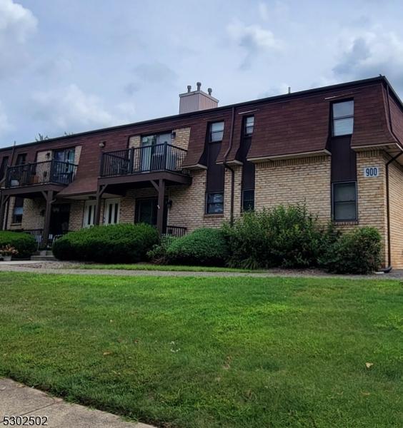 view of front of home featuring a balcony and a front lawn