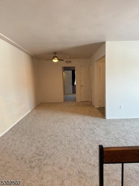 empty room with carpet floors and ceiling fan