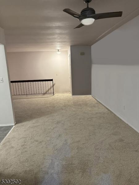 additional living space featuring carpet floors and ceiling fan