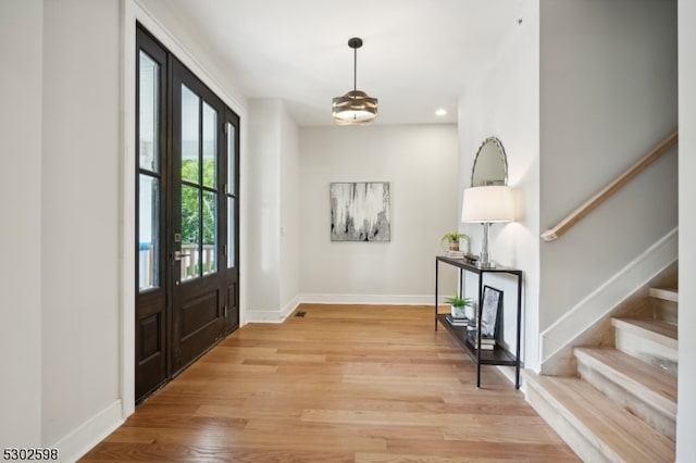 entryway featuring an inviting chandelier and light hardwood / wood-style floors