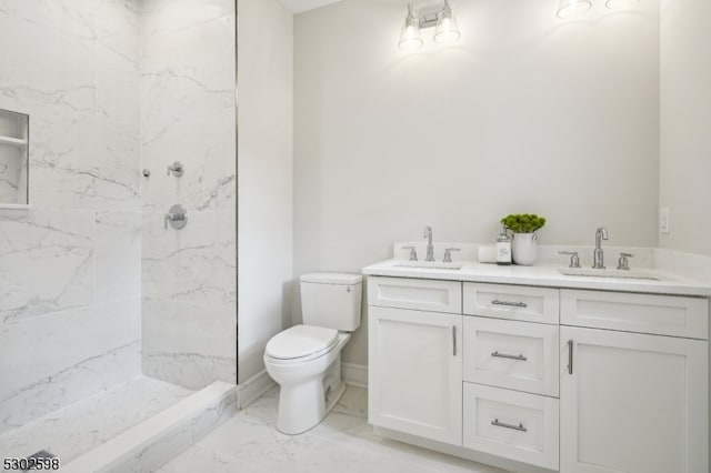 bathroom featuring toilet, vanity, and tiled shower