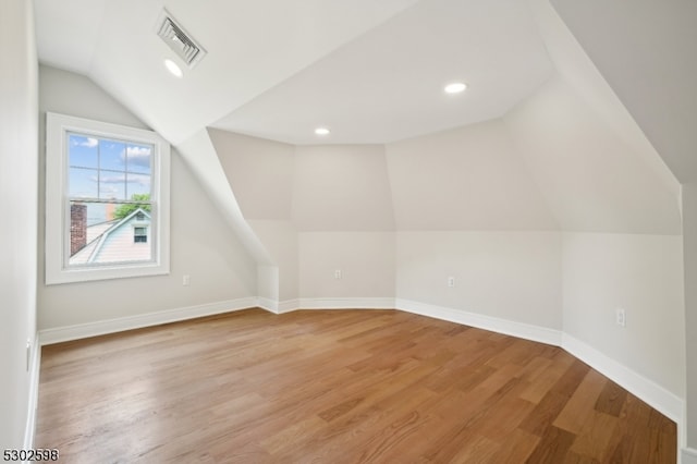 bonus room featuring vaulted ceiling and hardwood / wood-style flooring