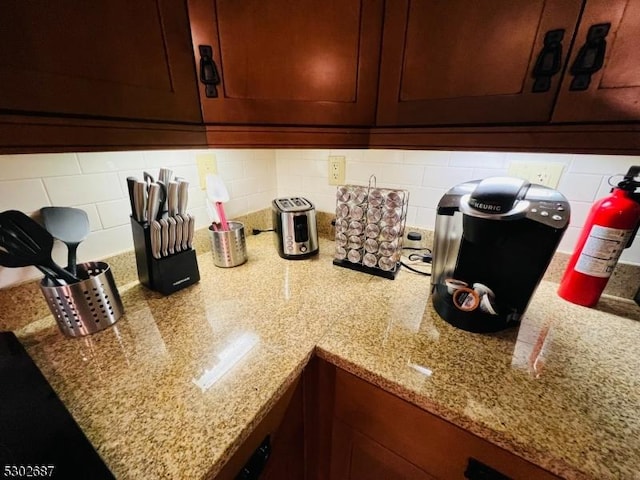 room details featuring light stone countertops and backsplash