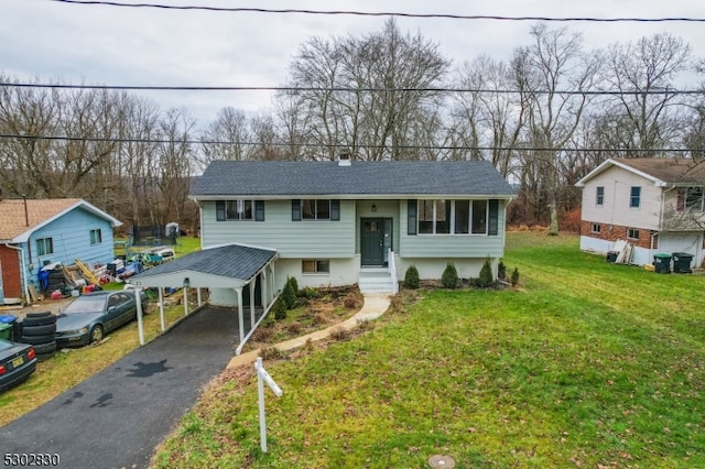 raised ranch featuring a front lawn and a carport