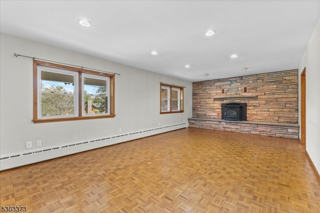 unfurnished living room featuring a baseboard heating unit, light parquet flooring, and a stone fireplace