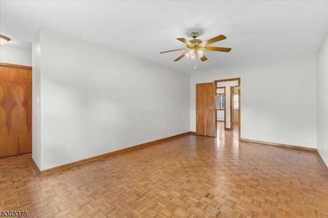 empty room featuring ceiling fan and light parquet floors