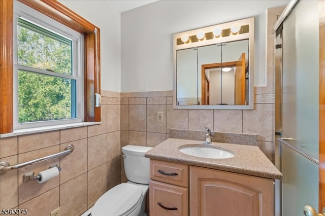 bathroom with tile walls, vanity, and toilet