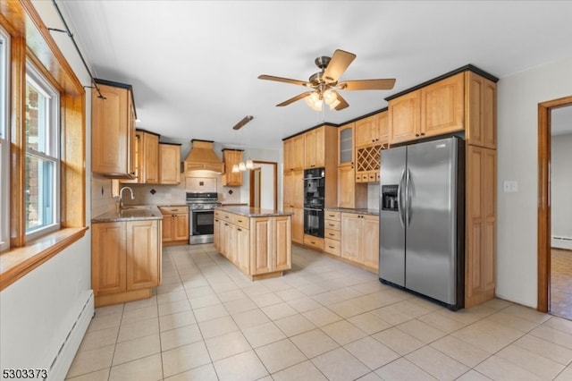 kitchen featuring ceiling fan, custom exhaust hood, stainless steel appliances, a center island, and a healthy amount of sunlight