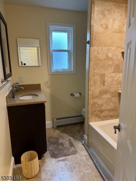 bathroom with baseboard heating, vanity, and toilet