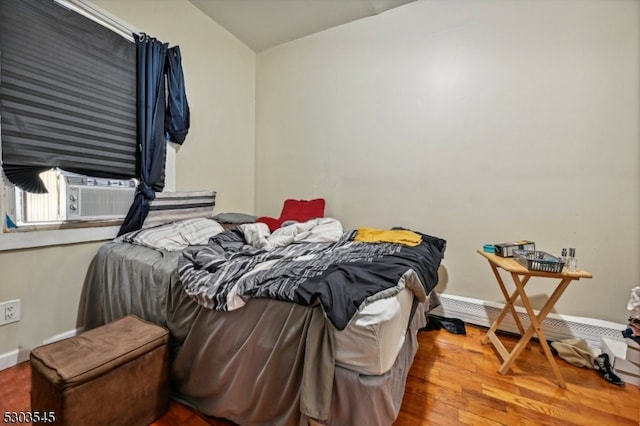 bedroom with cooling unit and wood-type flooring