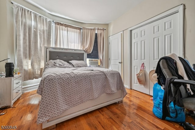 bedroom with cooling unit, hardwood / wood-style flooring, and a closet