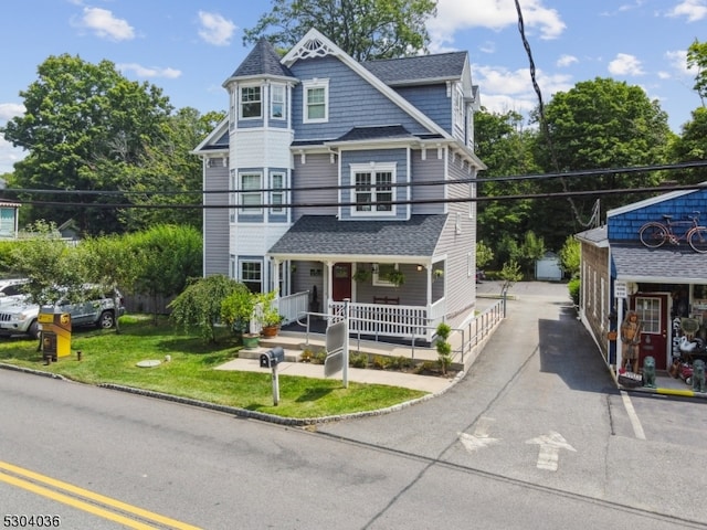 victorian home featuring a porch and a front lawn