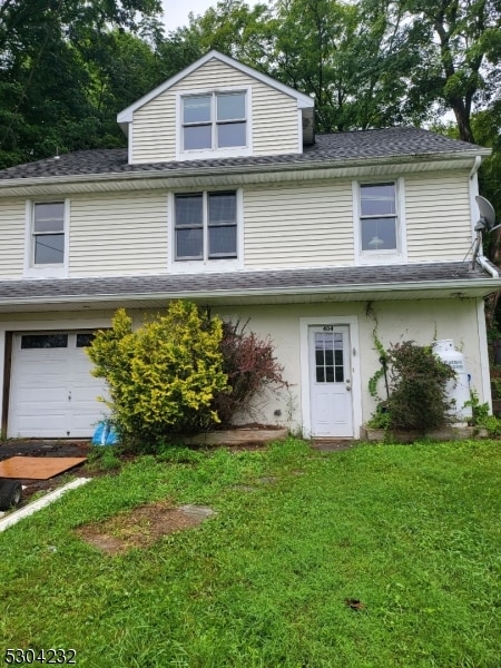 front facade featuring a garage and a front lawn