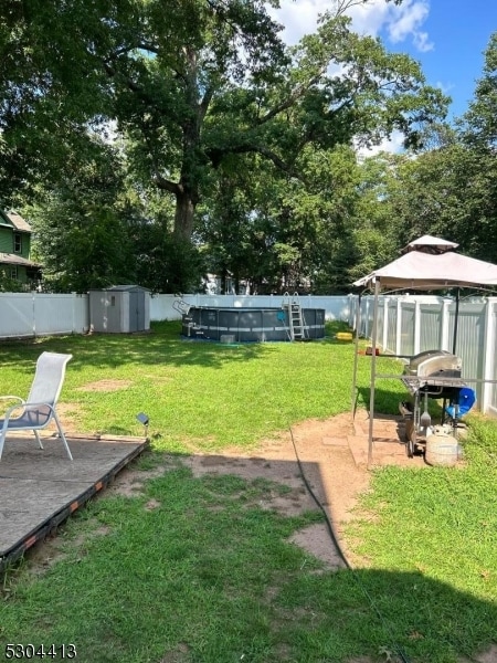 view of yard with a shed and a pool