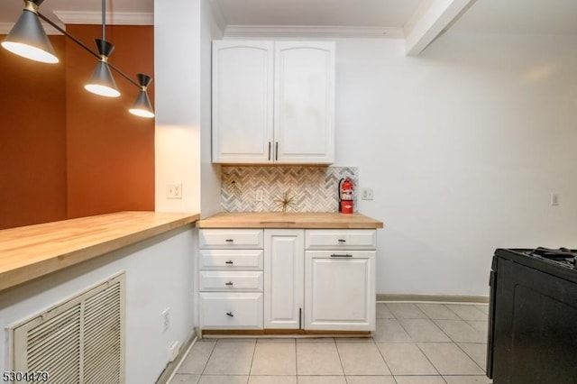 kitchen featuring butcher block counters, black range oven, hanging light fixtures, light tile patterned floors, and white cabinetry