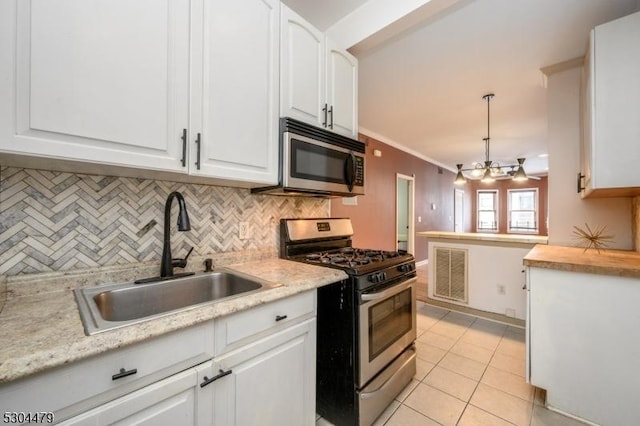 kitchen with white cabinets, appliances with stainless steel finishes, decorative light fixtures, and sink