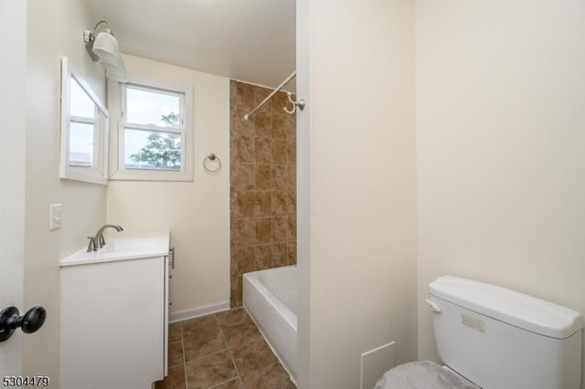 full bathroom featuring tile patterned flooring, vanity, tiled shower / bath combo, and toilet