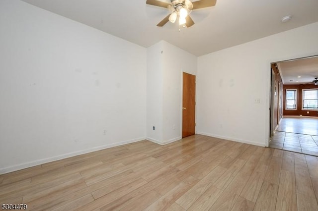 spare room with ceiling fan and light wood-type flooring