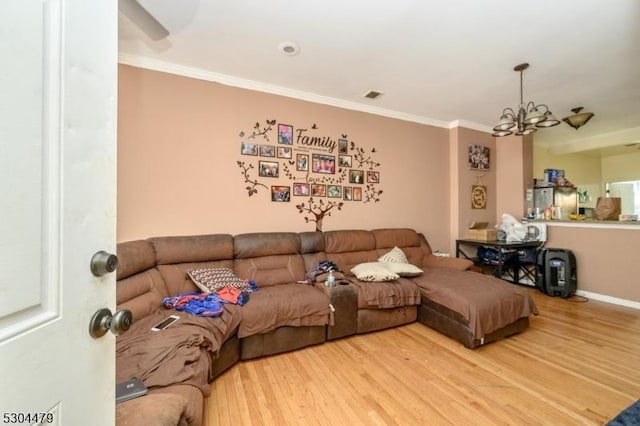 living room with hardwood / wood-style floors, a notable chandelier, and ornamental molding