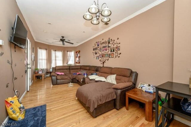 living room with crown molding, ceiling fan with notable chandelier, and light wood-type flooring