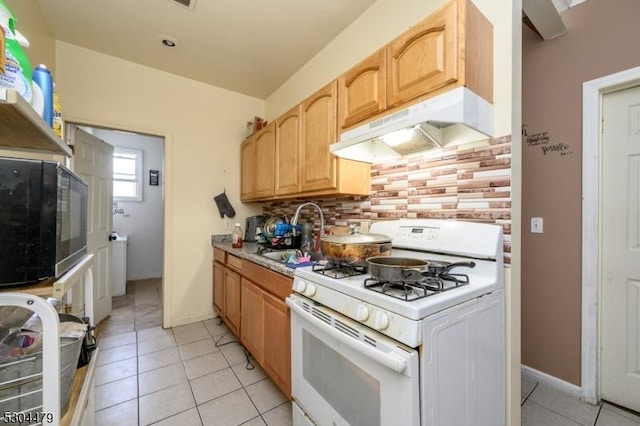 kitchen featuring sink, light brown cabinets, white range with gas cooktop, decorative backsplash, and light tile patterned floors