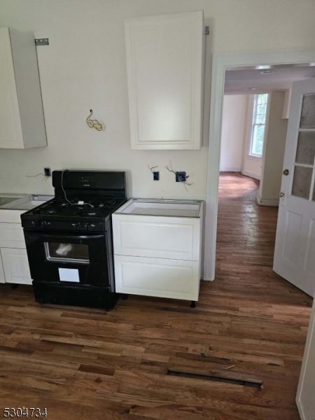 kitchen featuring white cabinetry, sink, black gas range oven, and dark hardwood / wood-style flooring