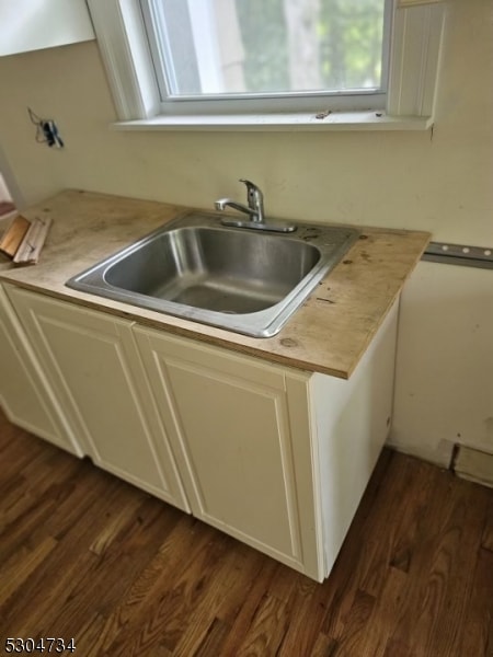 kitchen with sink, white cabinets, and dark hardwood / wood-style flooring