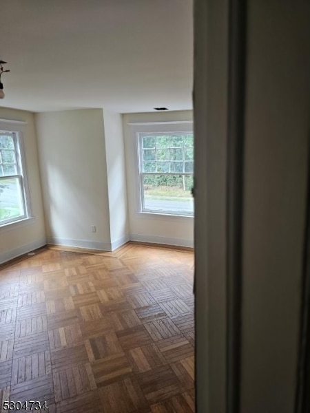 interior space with parquet flooring and a healthy amount of sunlight