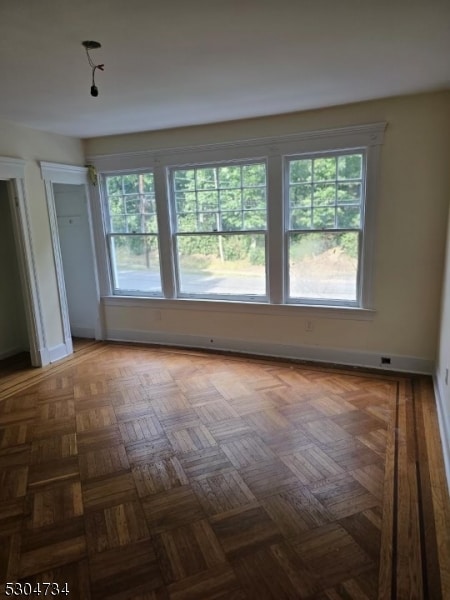 unfurnished room featuring dark parquet floors