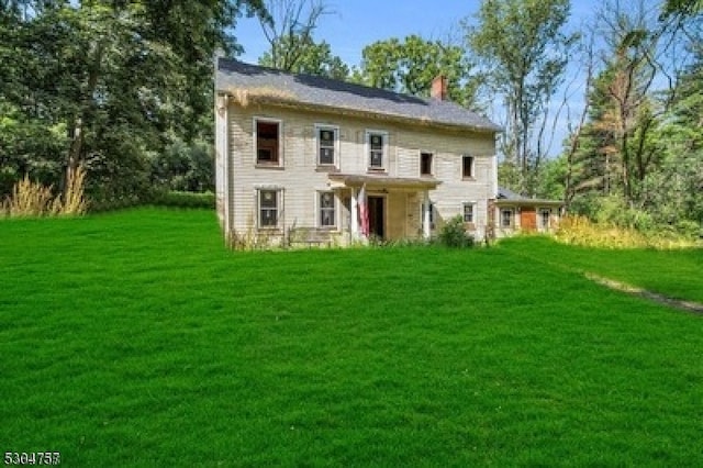 rear view of property featuring a lawn