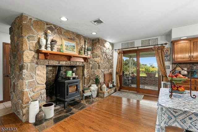 interior space with a wood stove and light hardwood / wood-style floors