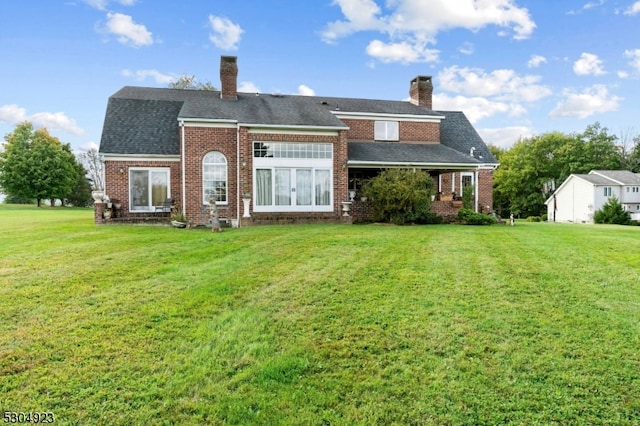 rear view of property with a lawn